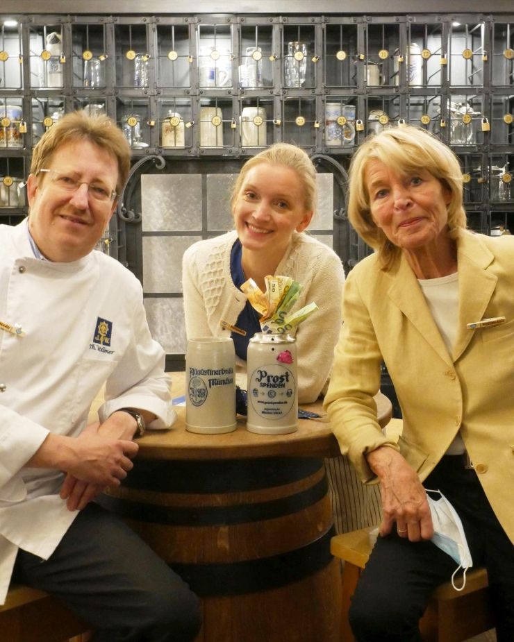 Thomas Vollmer, der Wirt der Augustiner-Festhalle, mit Amelie Diana (fka Liesl Weapon) und Hannelore Kiethe, der Vorsitzendenden der Tafel.